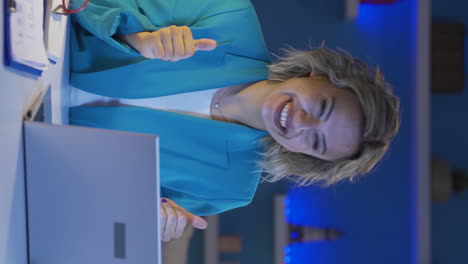 Vertical-video-of-Home-office-worker-woman-applauding-what-she-sees-on-laptop.